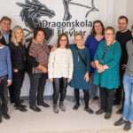 The project group in front of a painting (in the Dragonskolan) done by students.